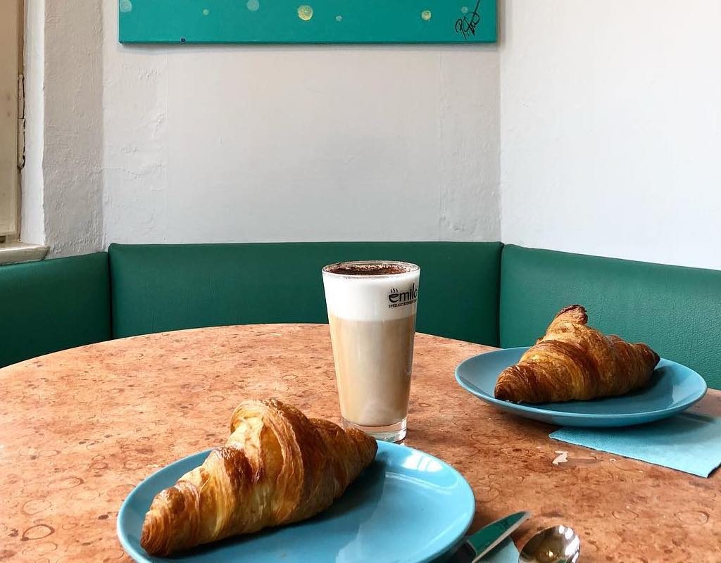 Zwei Croissants und ein Milchkaffee auf dem Tisch im Café